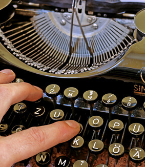 Eine Hand auf der Schreibmaschine, Symbolbild für das Impressum
